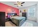 This bedroom features a ceiling fan, bright red accent wall, and two bedside tables at 7301 Deerberg Dr, Indianapolis, IN 46259