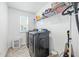 Bright laundry room with modern black washer and dryer, storage shelves, and window at 7301 Deerberg Dr, Indianapolis, IN 46259