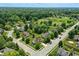 An aerial view shows a well-maintained neighborhood with mature trees and a community baseball field nearby at 8835 Harrison Pkwy, Fishers, IN 46038