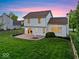 Relaxing backyard with a brick patio, built-in fire pit, green lawn and a partially wooded perimeter at 8835 Harrison Pkwy, Fishers, IN 46038