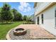 Beautifully landscaped backyard with a stone patio, fire pit, vibrant flowers, and privacy fence at 8835 Harrison Pkwy, Fishers, IN 46038