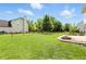 Well-kept backyard with a lush green lawn, wooden fence, brick patio, and inviting fire pit area at 8835 Harrison Pkwy, Fishers, IN 46038