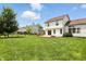 Expansive backyard featuring a patio area, fire pit, lush green grass, and a charming wooden fence at 8835 Harrison Pkwy, Fishers, IN 46038