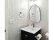 Elegant bathroom featuring a black vanity, stylish gold fixtures, and a modern oval mirror at 8835 Harrison Pkwy, Fishers, IN 46038