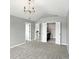Bedroom features neutral walls, plush carpeting, modern chandelier, and ensuite bathroom at 8835 Harrison Pkwy, Fishers, IN 46038