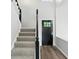 Bright entryway with a black front door, gray stairs, and beautiful hard wood flooring at 8835 Harrison Pkwy, Fishers, IN 46038