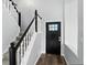 Bright entryway with a black front door, gray stairs, and beautiful hard wood flooring at 8835 Harrison Pkwy, Fishers, IN 46038