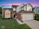 Traditional home with brick and siding, two-car garage, and manicured lawn with tidy landscaping at 8835 Harrison Pkwy, Fishers, IN 46038