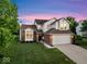 Traditional house featuring an attached garage, front lawn and manicured landscaping and trees at 8835 Harrison Pkwy, Fishers, IN 46038