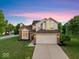 Inviting two-story house with attached garage, lush green lawn, and classic architectural details at 8835 Harrison Pkwy, Fishers, IN 46038