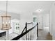 Bright hallway with hardwood floors and modern chandelier, providing an open view of the living area below at 8835 Harrison Pkwy, Fishers, IN 46038
