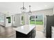 Open-concept kitchen with a large island, stainless steel refrigerator, and a sliding glass door to the backyard at 8835 Harrison Pkwy, Fishers, IN 46038