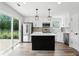 Modern kitchen with white cabinets, black island, stainless steel appliances and backyard view at 8835 Harrison Pkwy, Fishers, IN 46038