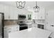 Modern kitchen showcases white cabinets, stainless steel appliances, quartz countertops, and stylish pendant lighting at 8835 Harrison Pkwy, Fishers, IN 46038