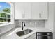 Bright kitchen featuring white cabinets, stainless steel sink, stylish backsplash, and quartz countertops at 8835 Harrison Pkwy, Fishers, IN 46038