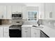 Updated kitchen boasts white cabinetry, stainless steel appliances, and quartz counters with a stylish backsplash at 8835 Harrison Pkwy, Fishers, IN 46038