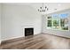 Bright living room features a fireplace, hardwood floors, chandelier, and large windows at 8835 Harrison Pkwy, Fishers, IN 46038