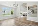 Bright living room featuring hardwood floors, a modern chandelier, and large windows at 8835 Harrison Pkwy, Fishers, IN 46038