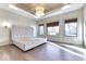 Spacious bedroom showcasing a large tufted headboard, wood floors, and natural light from three windows at 886 J Mccool Way, Greenwood, IN 46142