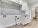 Well-lit laundry room featuring patterned backsplash, washer/dryer hookups, and white cabinetry with black hardware at 886 J Mccool Way, Greenwood, IN 46142