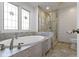 Bright bathroom featuring a soaking tub with marble surround and glass enclosed shower at 111 N 8Th St, Zionsville, IN 46077