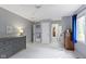 Neutral bedroom featuring a dresser, window with blue curtains, and doorways leading to other rooms at 111 N 8Th St, Zionsville, IN 46077
