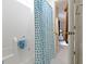 Close-up of a white shower with a blue and white curtain, offering a glimpse into a connected bedroom at 111 N 8Th St, Zionsville, IN 46077