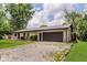 Single-story home with gravel driveway leading to a spacious two-car garage at 11230 N College Ave, Carmel, IN 46032
