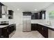 Modern kitchen with stainless steel appliances and sleek dark cabinetry at 11230 N College Ave, Carmel, IN 46032