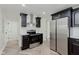 Modern kitchen boasts stainless steel appliances, white backsplash, and stylish dark cabinetry at 11230 N College Ave, Carmel, IN 46032