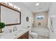 Well-lit bathroom featuring a dark wood vanity, decorative mirror, and tiled shower-tub combination at 1141 W 35Th St, Indianapolis, IN 46208
