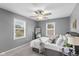 Cozy bedroom with a ceiling fan, ample natural light from two windows, and stylish decor at 1141 W 35Th St, Indianapolis, IN 46208