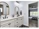 Bathroom featuring double sinks, white cabinetry, gold framed mirrors and matte black fixtures at 11626 Laurel Springs Cir, Noblesville, IN 46060