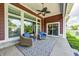 Comfortable covered patio with wicker chairs, ceiling fan, rug, and views of the green backyard at 11626 Laurel Springs Cir, Noblesville, IN 46060