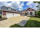 Wide driveway leading to a three-car garage of a two-story home featuring beautiful landscaping and curb appeal at 11626 Laurel Springs Cir, Noblesville, IN 46060
