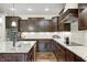 Modern kitchen with dark wood cabinetry, granite countertops, and stainless steel appliances at 11626 Laurel Springs Cir, Noblesville, IN 46060