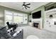 Cozy living room with a fireplace, built-in shelves, and an abundance of natural light, creating a warm space at 11626 Laurel Springs Cir, Noblesville, IN 46060