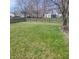 Large backyard enclosed by a wooden fence, featuring green grass and mature trees at 11985 Cat Tail Ct, Noblesville, IN 46060