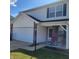 Two-story home featuring an attached garage and a cozy front porch seating area at 11985 Cat Tail Ct, Noblesville, IN 46060