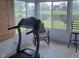 Sunroom featuring a treadmill and views of a pond and backyard at 11985 Cat Tail Ct, Noblesville, IN 46060