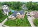 Aerial view of home with manicured lawn, red door, inground pool and mature trees at 11995 Gray Eagle Dr, Fishers, IN 46037