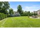 Beautiful backyard with manicured lawn, mature trees, and outdoor patio area for entertaining at 11995 Gray Eagle Dr, Fishers, IN 46037