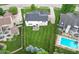 Aerial shot of home with well-manicured lawn, small patio set, manicured trees and a nearby pool at 11995 Gray Eagle Dr, Fishers, IN 46037