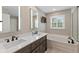 Bright bathroom with double vanity, large mirror, soaking tub, and stylish fixtures at 11995 Gray Eagle Dr, Fishers, IN 46037