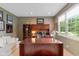Home office features a large desk, built-in shelving, and natural light from a large window at 11995 Gray Eagle Dr, Fishers, IN 46037