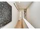Upstairs hallway with a modern art piece and white railings, leading to the bedrooms at 1311 Central Ave, Indianapolis, IN 46202