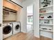 Bright laundry room with washer, dryer, shelving and view into bright living space at 1311 Central Ave, Indianapolis, IN 46202