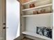 This mudroom features built-in shelves with baskets and a bench with decorative pillows at 1311 Central Ave, Indianapolis, IN 46202