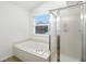 Relaxing bathroom features a garden tub, separate glass-enclosed shower, and natural light at 13264 Penneagle Dr, Carmel, IN 46033