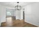 Bright dining room with modern light fixture open to kitchen, with hardwood floors at 13264 Penneagle Dr, Carmel, IN 46033